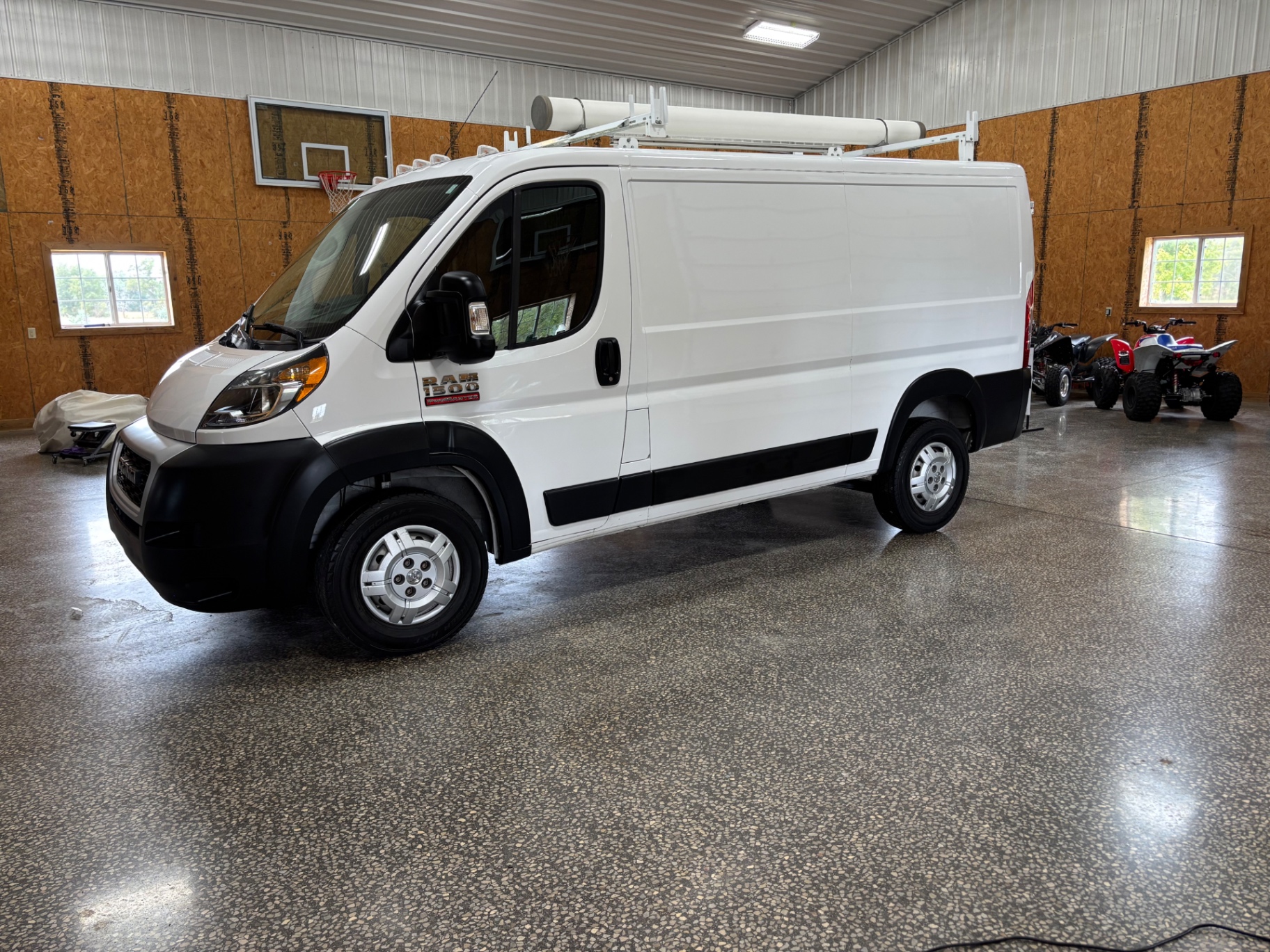 Freshly detailed white Ram ProMaster work van inside Blacktop Garage