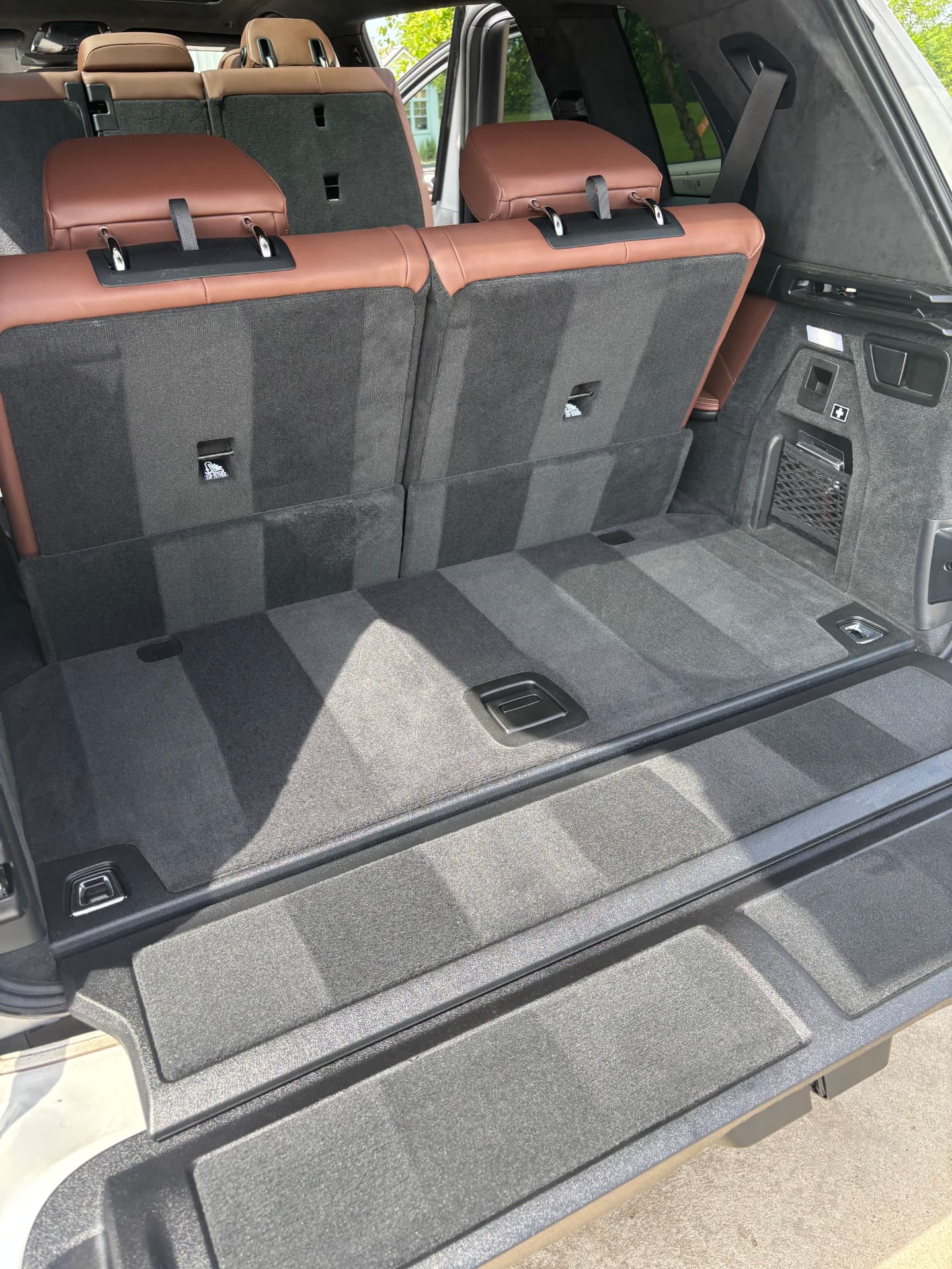 Deep-cleaned SUV cargo area with vacuumed carpet and conditioned leather seats